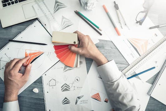 Designer selecting brand colors and sketching logo concepts to define your brand voice, story, and visual identity for a cohesive business presence