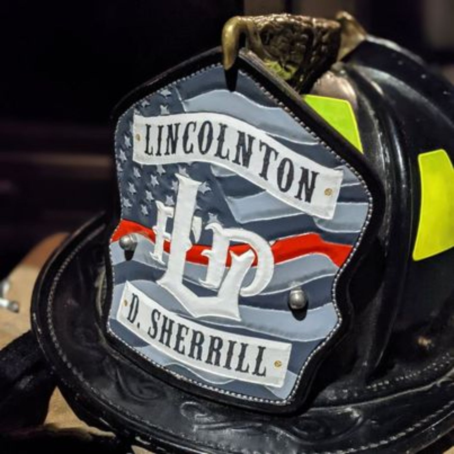 Custom firefighter helmet shield with American flag design, personalized leather front with unit number and firefighter name. Handcrafted fire helmet shield for professional firefighters, made for durability and pride on the job.