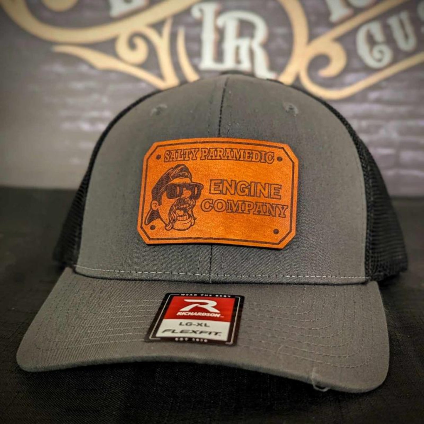 Custom firefighter and EMS hats featuring The Salty Paramedic's leather patch design, shown on Richardson 112 and 110 hats for first responders.