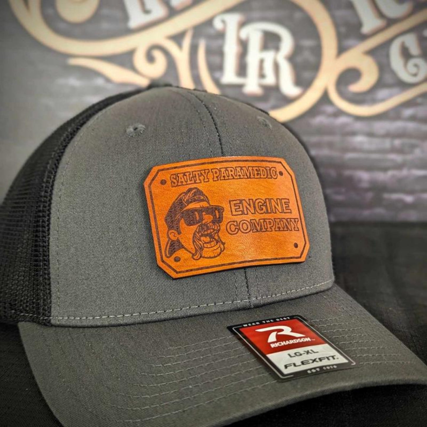 Custom firefighter and EMS hats featuring The Salty Paramedic's leather patch design, shown on Richardson 112 and 110 hats for first responders.