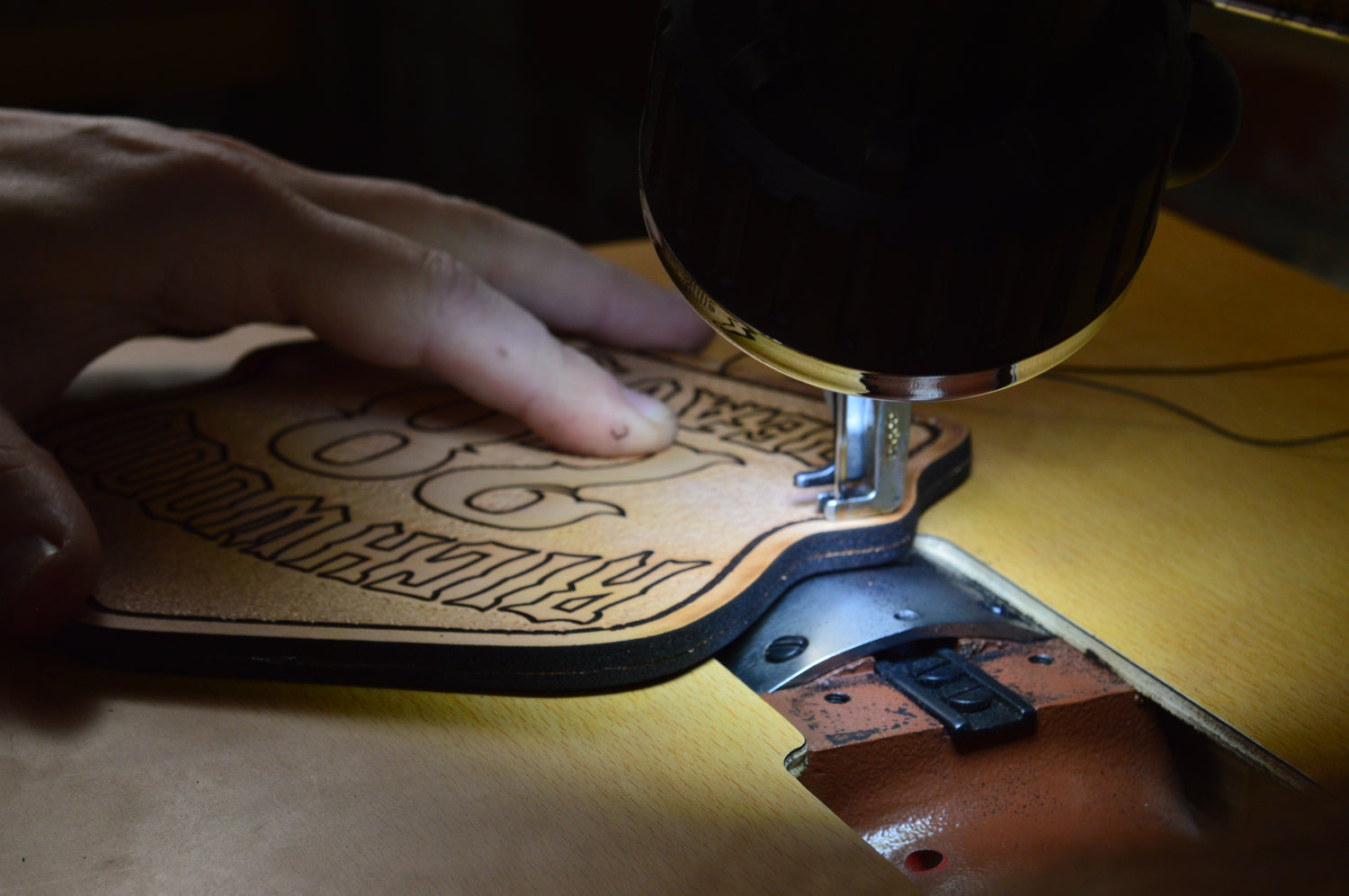 Close-up of leather firefighter helmet shield being handcrafted with a sewing machine