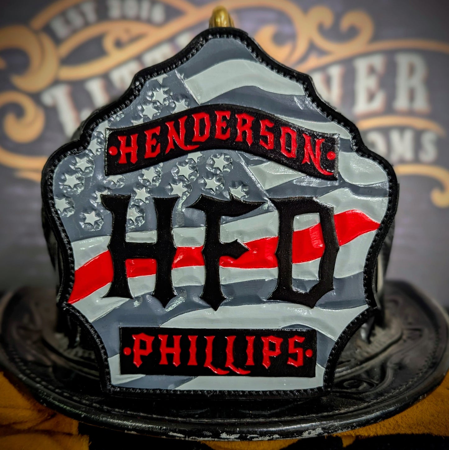 Custom firefighter helmet shield with American flag design, personalized leather front with unit number and firefighter name. Handcrafted fire helmet shield for professional firefighters, made for durability and pride on the job.