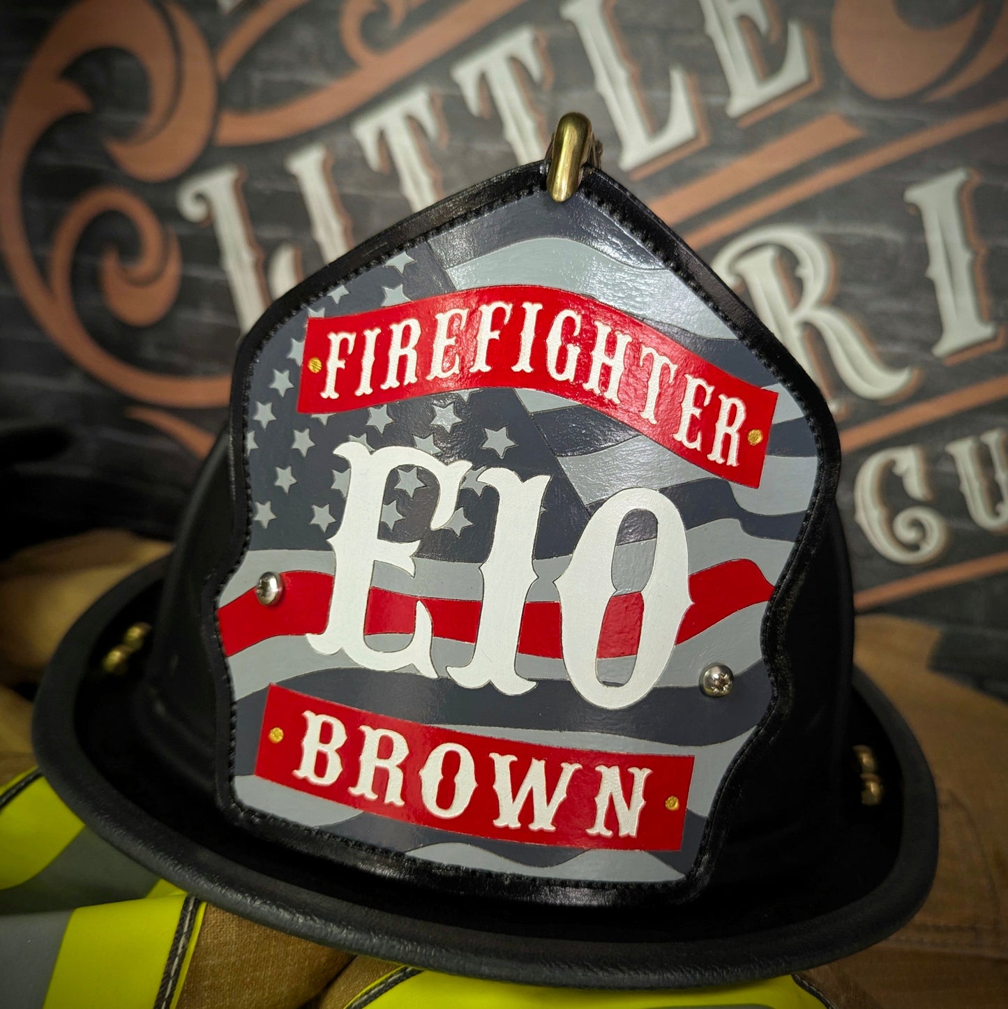 Custom firefighter helmet shield with American flag design, personalized leather front with unit number and firefighter name. Handcrafted fire helmet shield for professional firefighters, made for durability and pride on the job.
