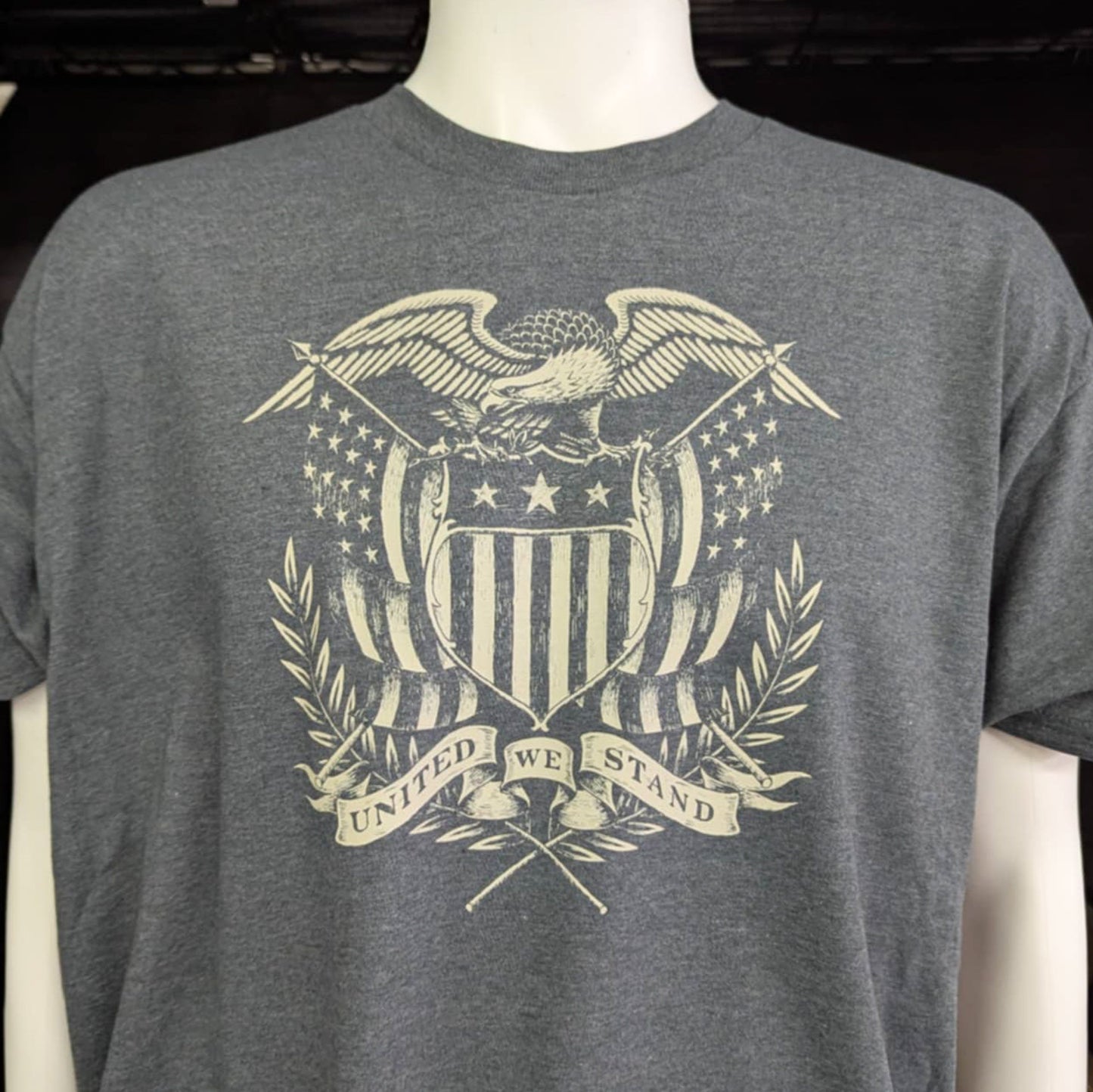 Dark gray t-shirt with vintage eagle and shield crest and “United We Stand” banner – patriotic graphic tee for American pride and unity