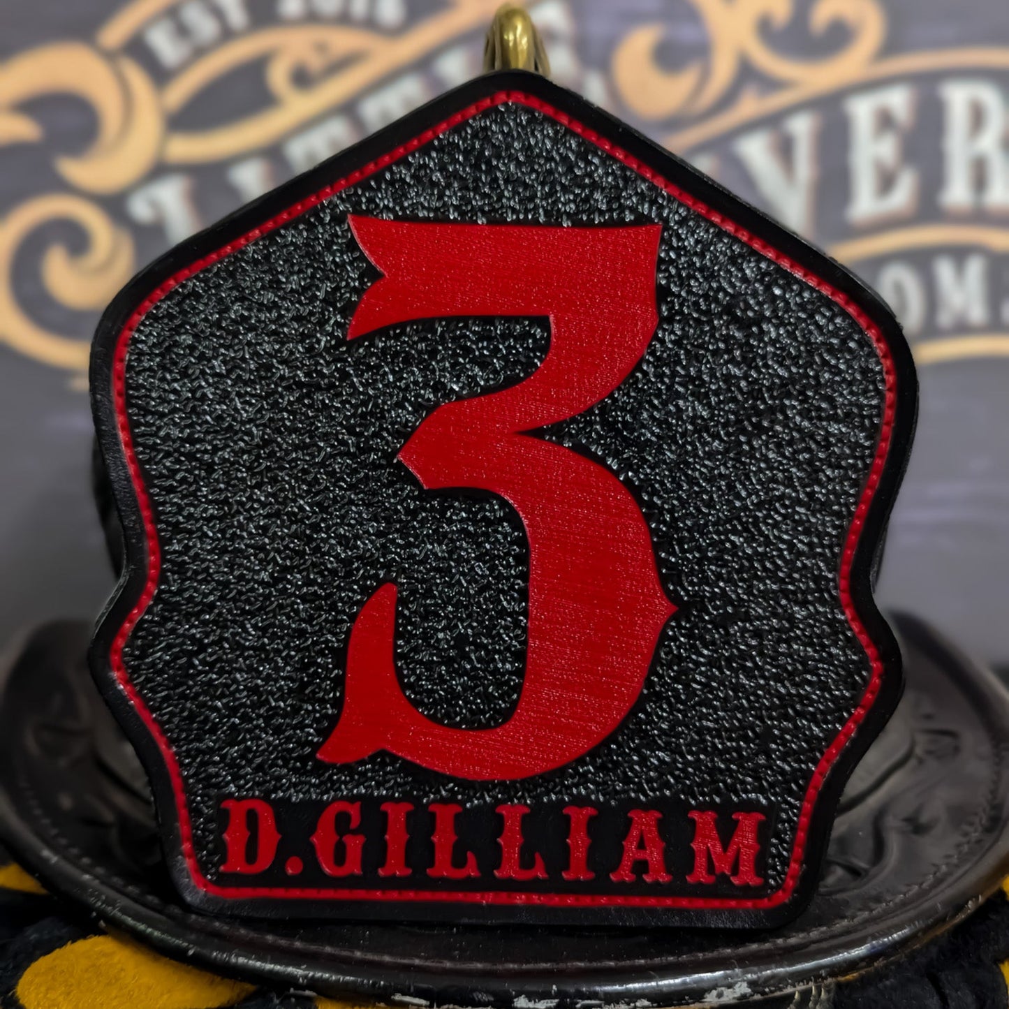 Custom black leather firefighter helmet shield with large red number 3 and D. Gilliam name.