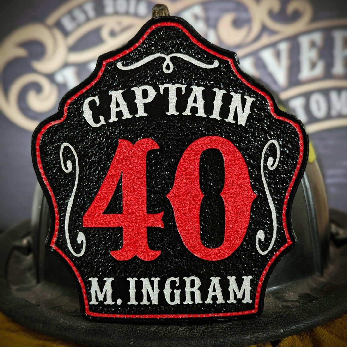 Custom leather firefighter helmet shield with captain title, bold red number 40, and M. Ingram name.