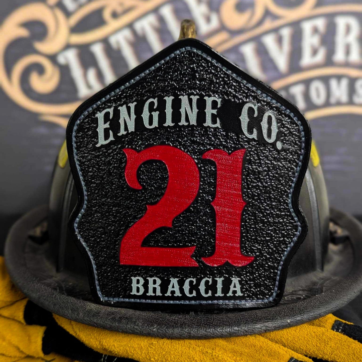 Black leather firefighter helmet shield with Engine Company 21 design and bold red numbers.