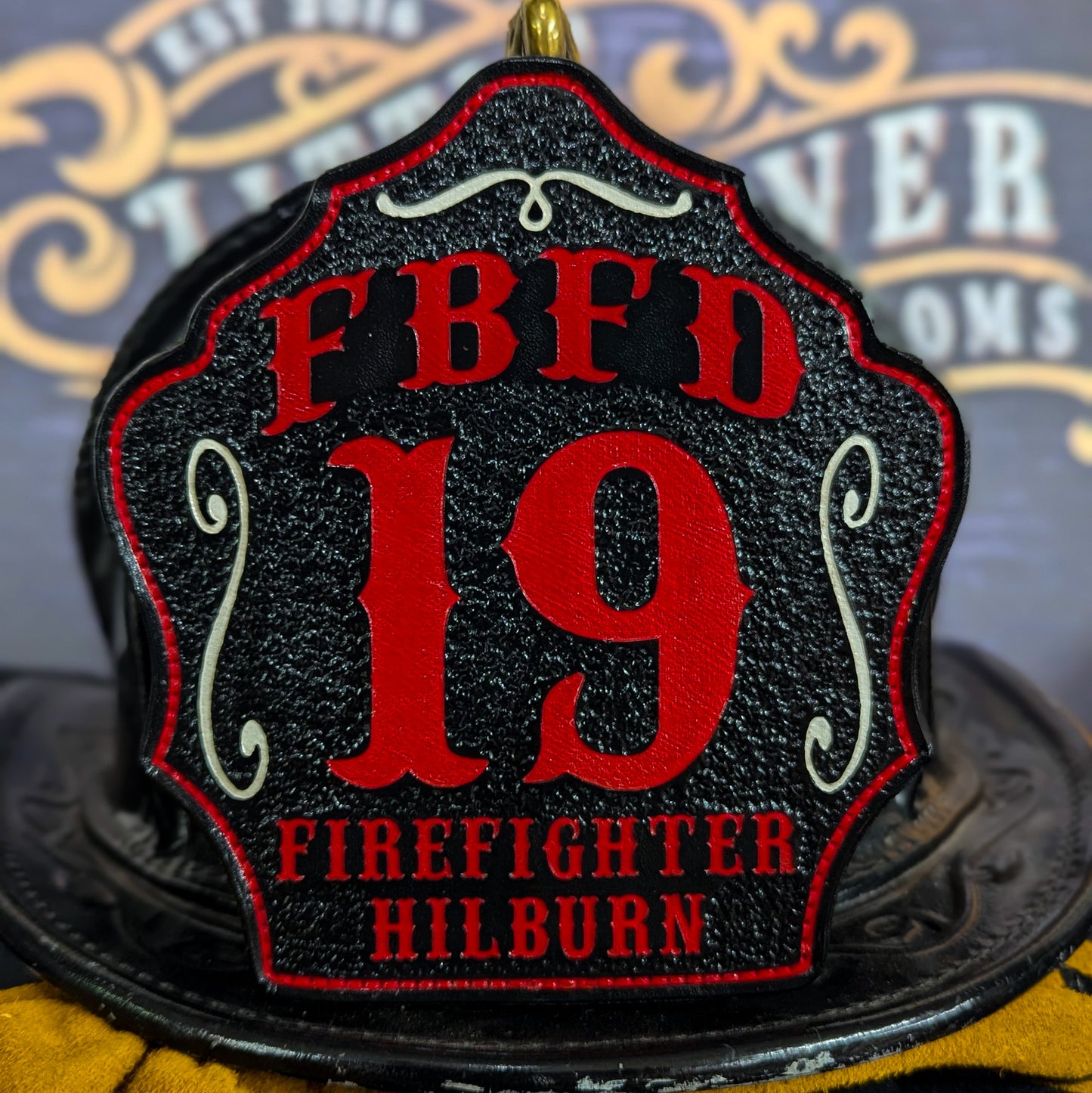 Leather firefighter helmet shield with FBFD design, large red number 19, and firefighter Hilburn name.