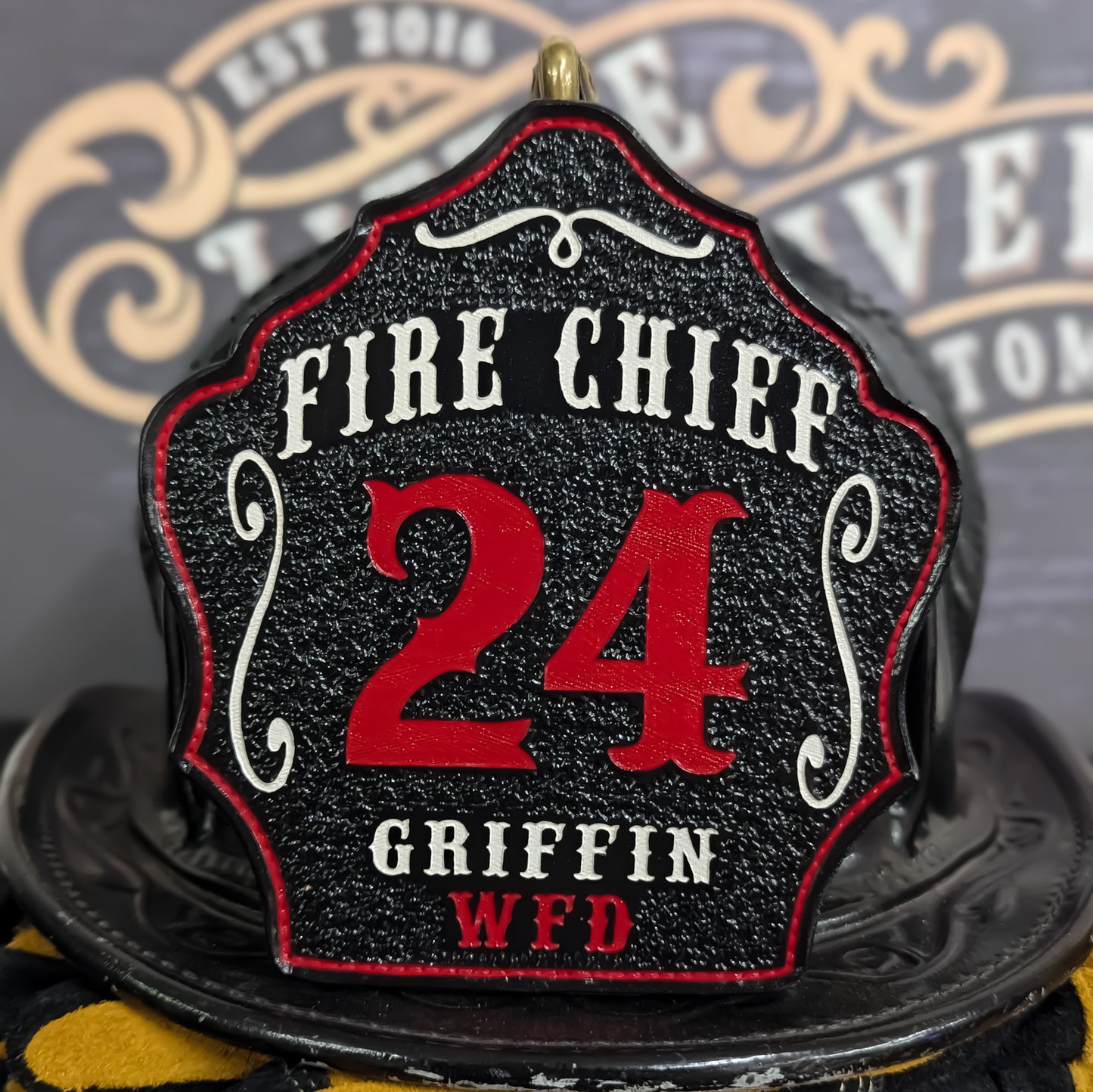 Black leather firefighter helmet shield with Fire Chief title, bold red number 24, and custom WFD details.