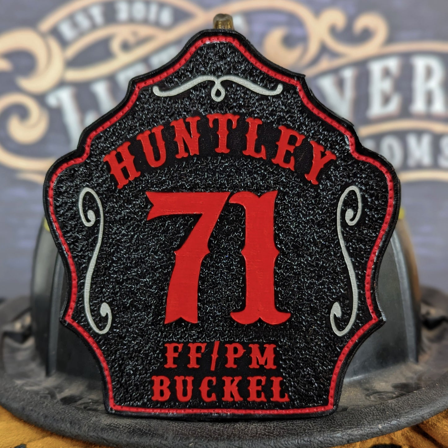 Leather firefighter helmet shield with Huntley lettering, bold red number 71, and FF/PM Buckel details.
