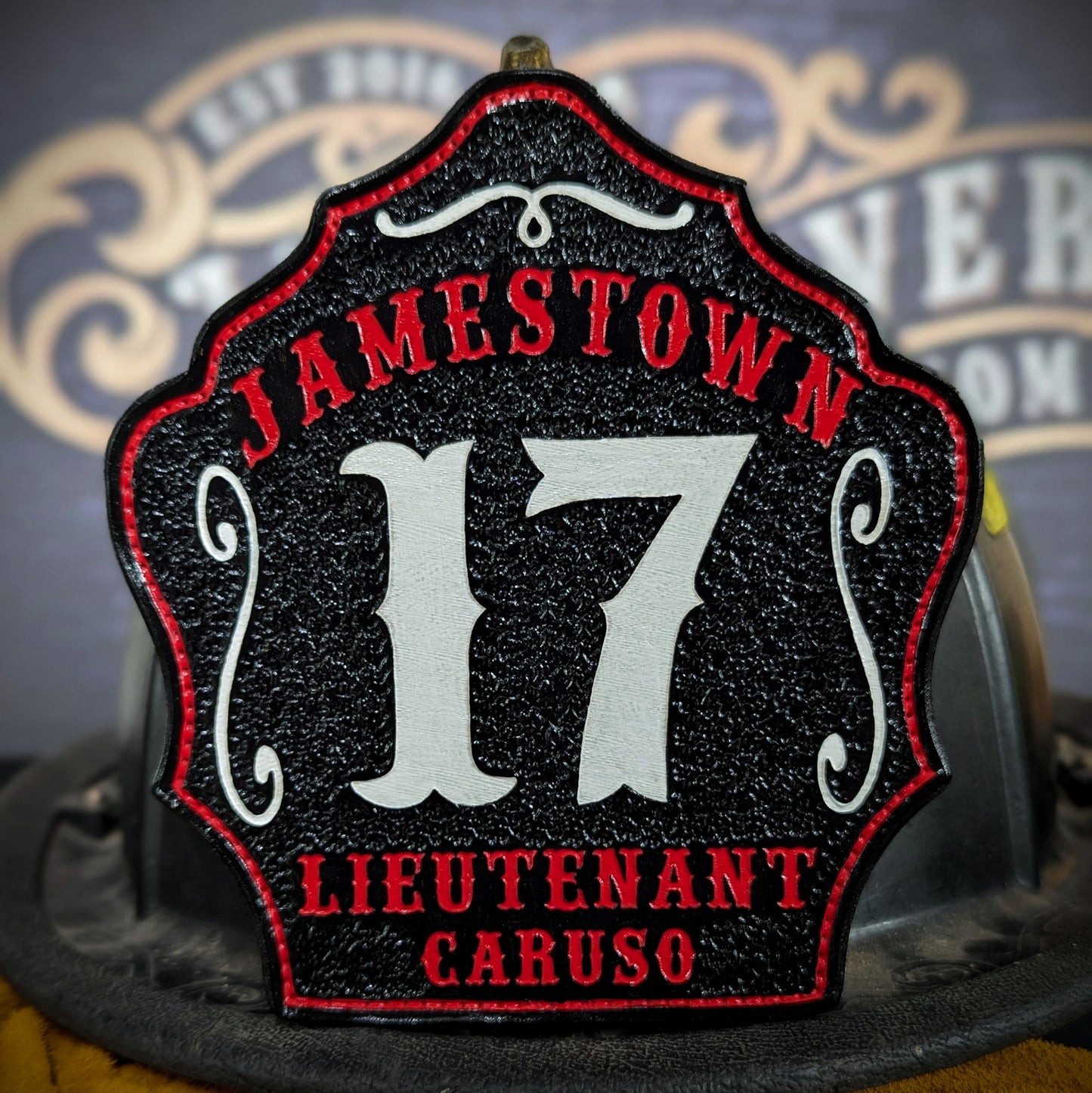 Custom black leather firefighter helmet shield with Jamestown lettering, bold white number 17, and lieutenant Caruso details.