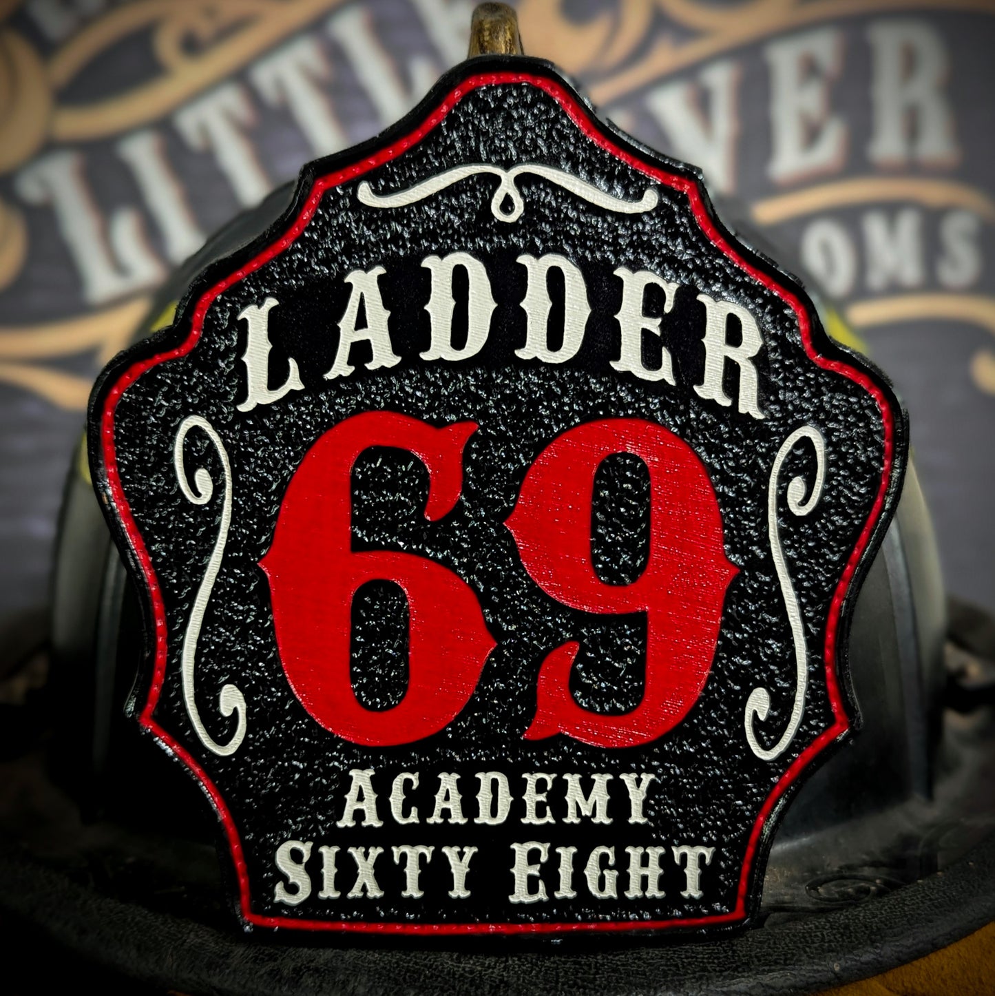Leather firefighter helmet shield with Ladder 69 design featuring bold red numbers and academy details.