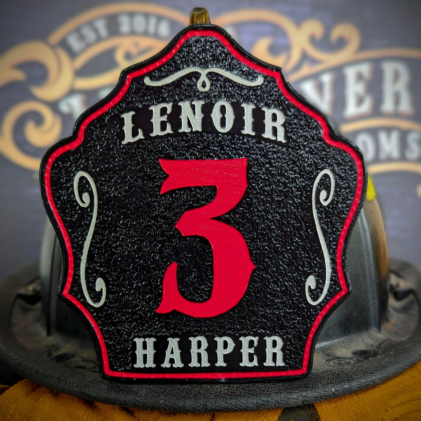 Leather firefighter helmet shield with Lenoir lettering, bold red number 3, and Harper name.