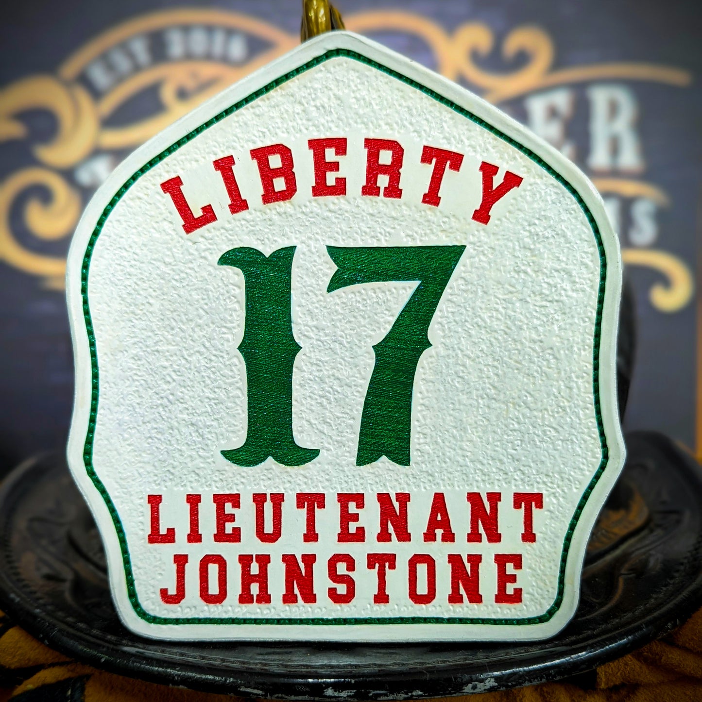 White leather firefighter helmet shield with Liberty lettering, green number 17, and lieutenant Johnstone details.