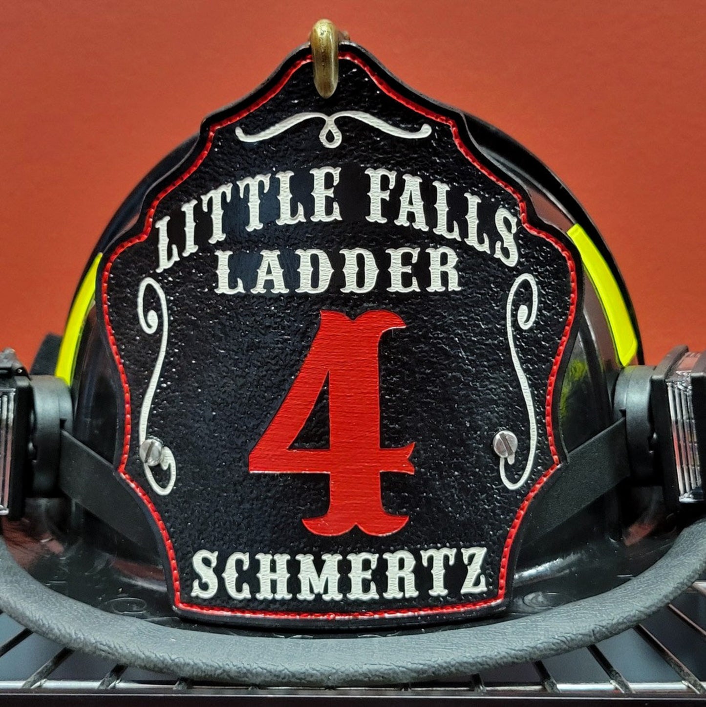 Black leather firefighter helmet shield with Little Falls Ladder design, bold red number 4, and personalized name.