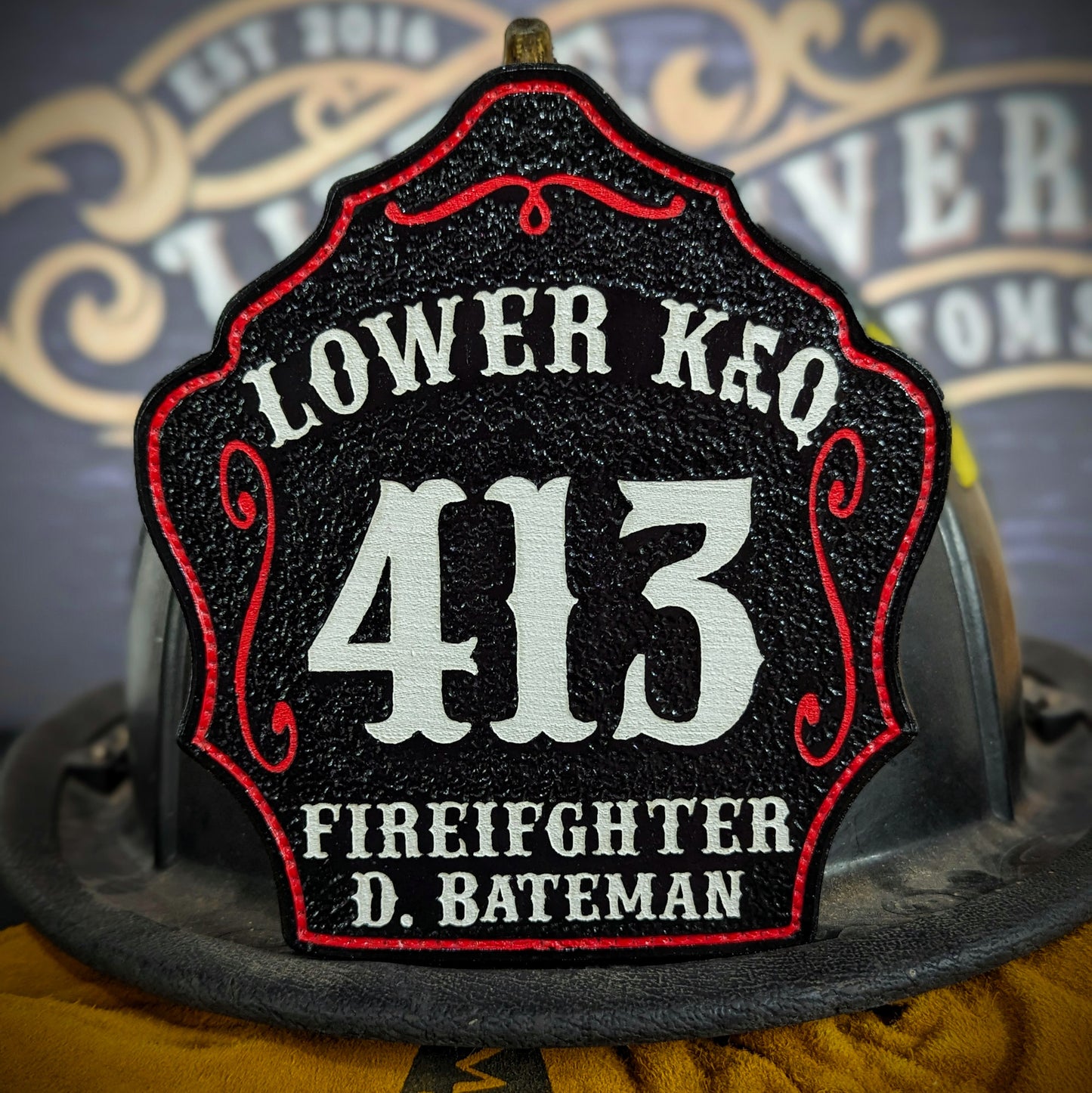 Black leather firefighter helmet shield with Lower Key lettering, bold white number 413, and firefighter D. Bateman name.