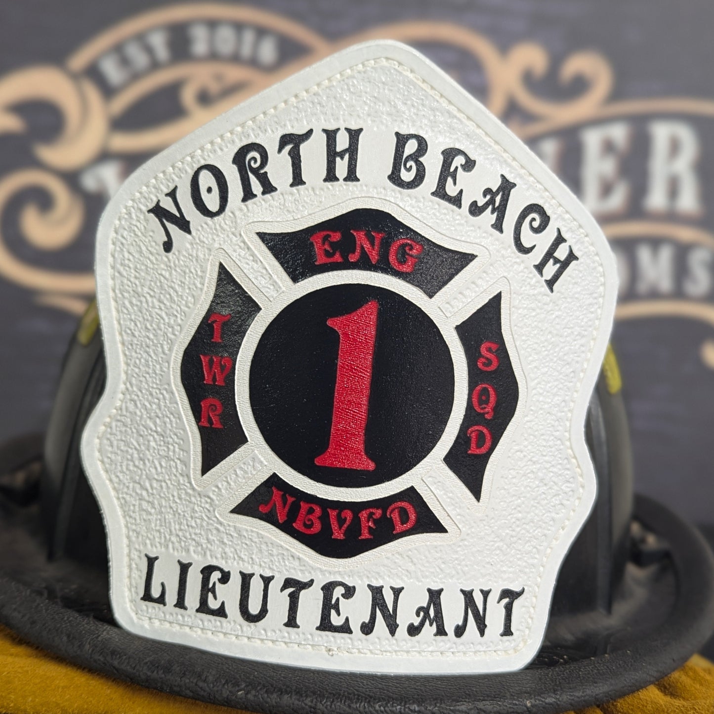 White leather firefighter helmet shield with red number 1 and Maltese cross design