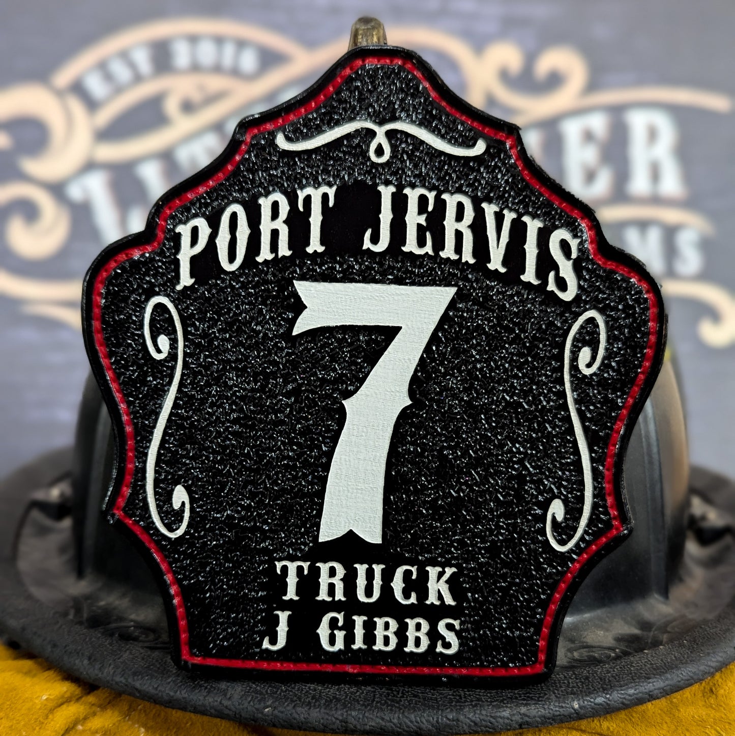 Leather firefighter helmet shield with Port Jervis design, large white number 7, and truck company details.
