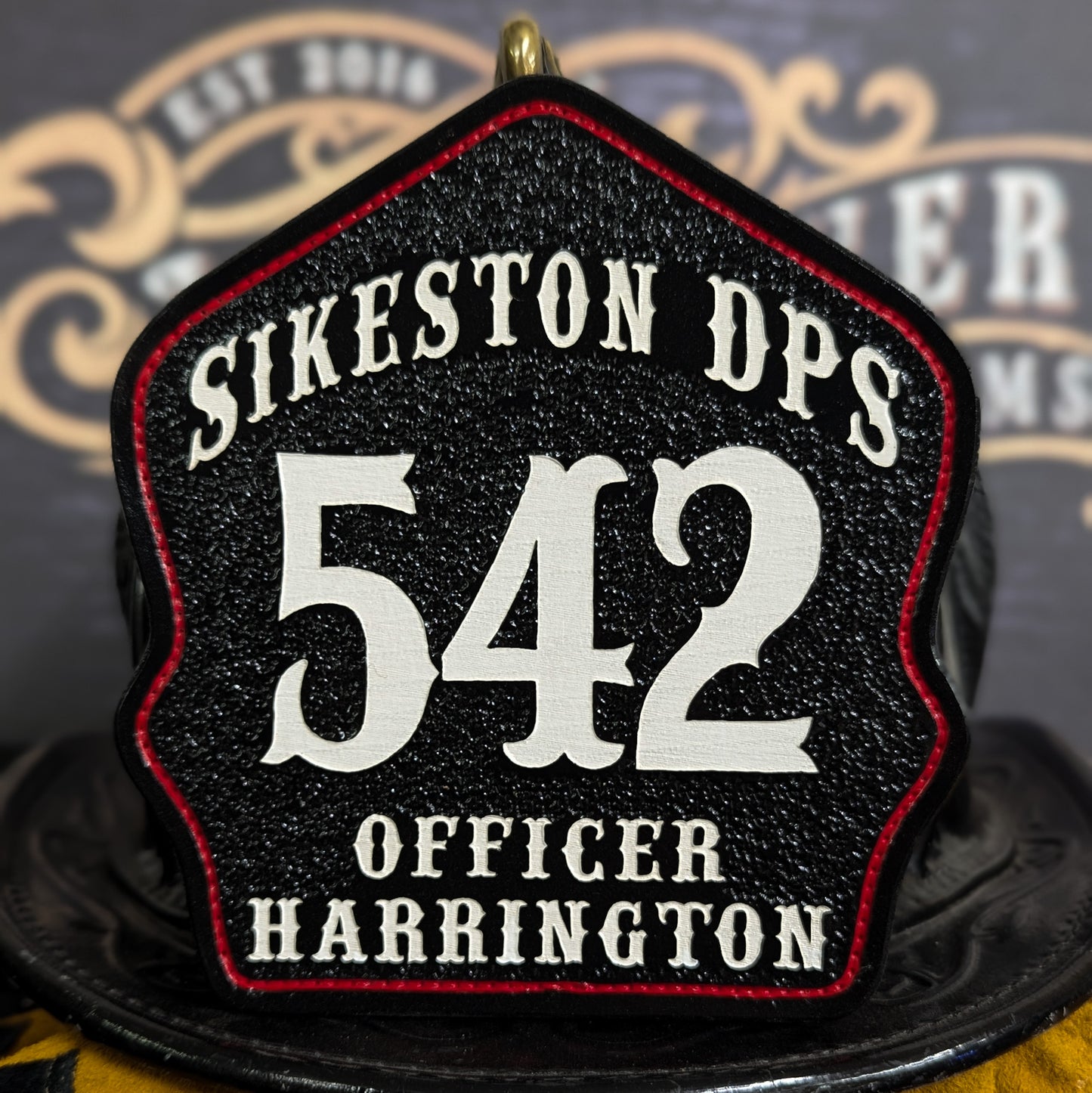 Leather firefighter helmet shield with Sikeston DPS design, white 542 numbers, and officer rank.
