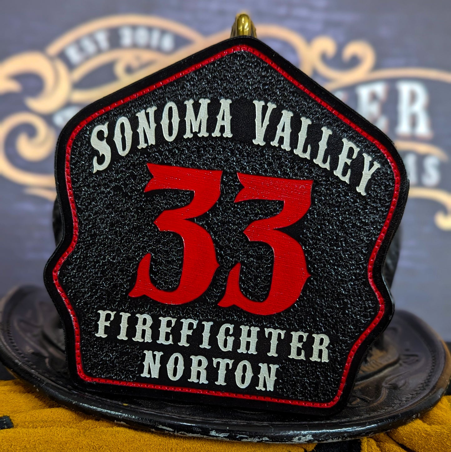 Custom black leather firefighter helmet shield with Sonoma Valley lettering, bold red number 33, and firefighter Norton name.