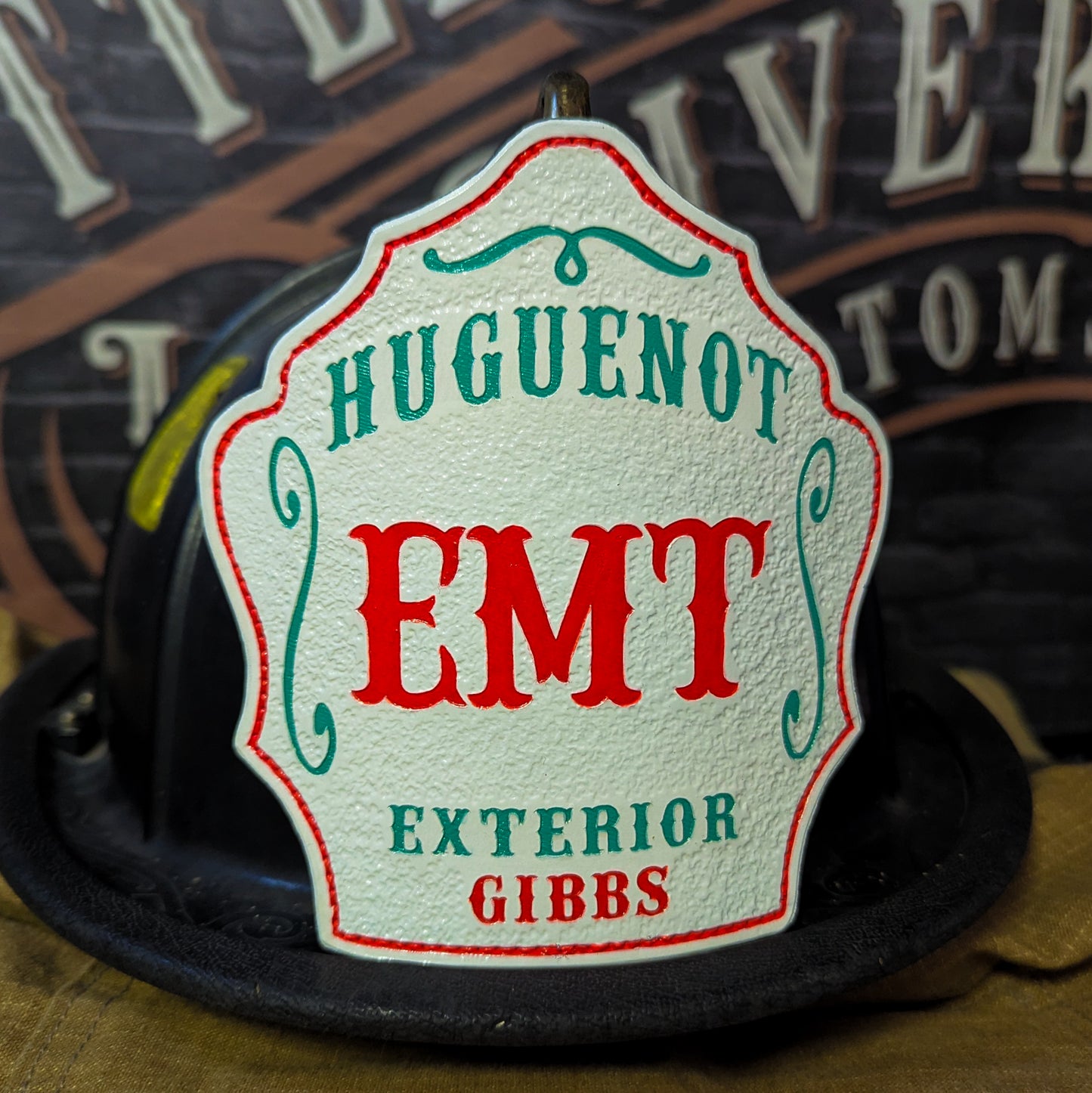 Custom leather firefighter helmet shield with red EMT, Huguenot Exterior Gibbs in teal on white, by Little River Customs