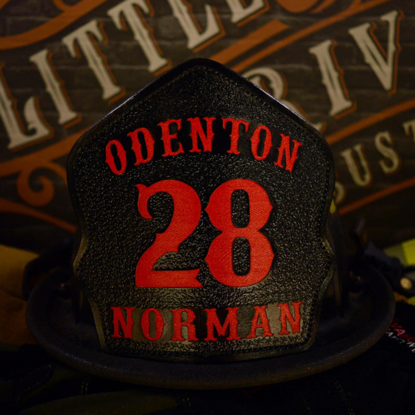 Custom leather firefighter helmet shield for Odenton, black with red 28 and Norman name, hand painted by Little River Customs
