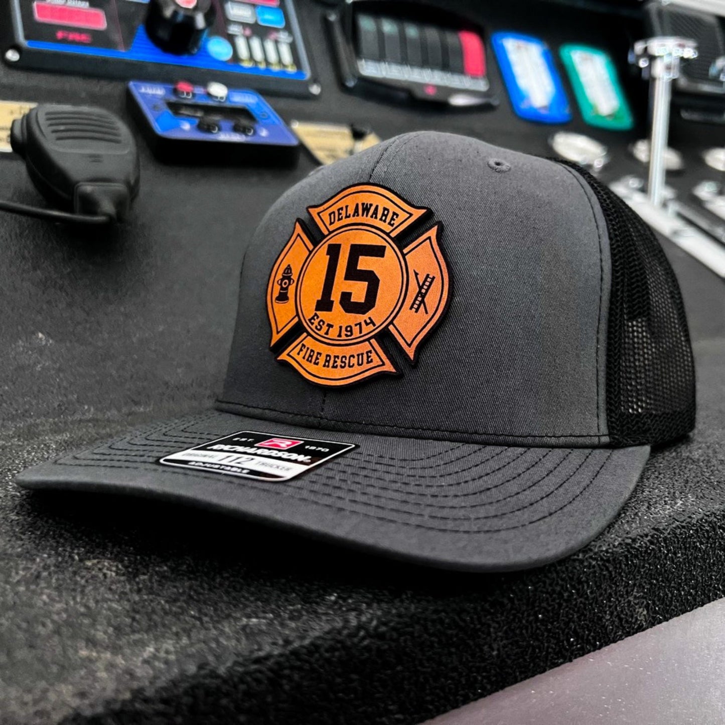 Charcoal Richardson firefighter hat with custom Maltese leather patch design, professional gear for fire rescue crews.