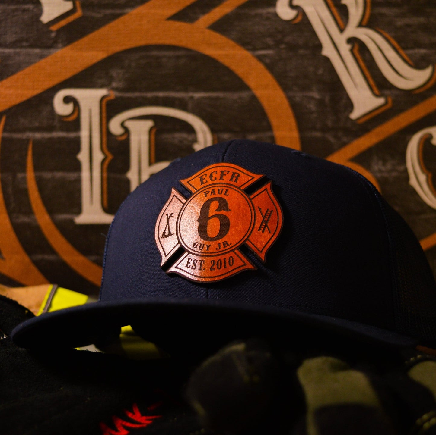 Navy blue Richardson firefighter hat with custom Maltese leather patch design, tough and professional fire service headwear.