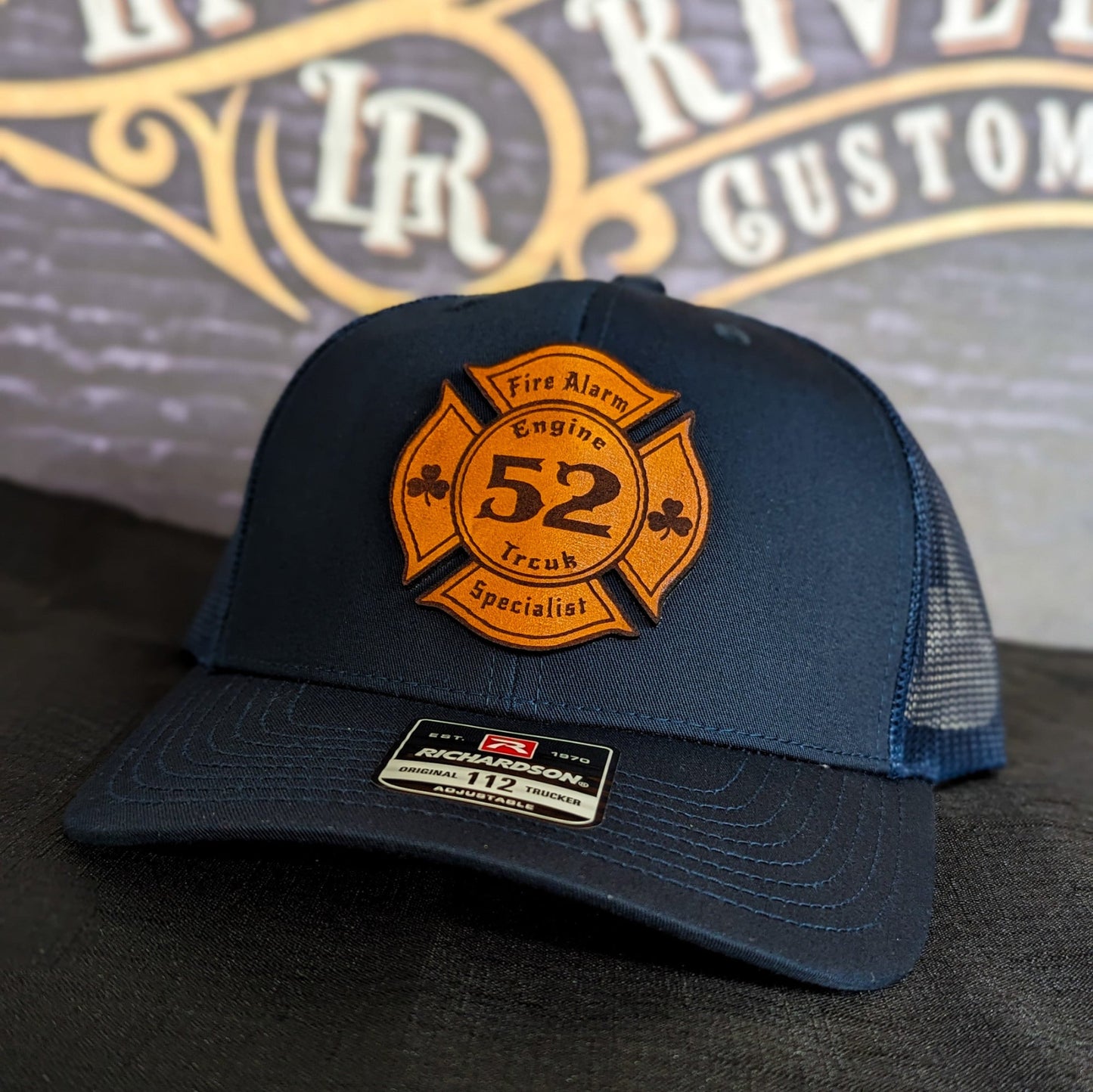 Navy Richardson firefighter hat with custom Maltese leather patch design, classic professional style for fire service crews.