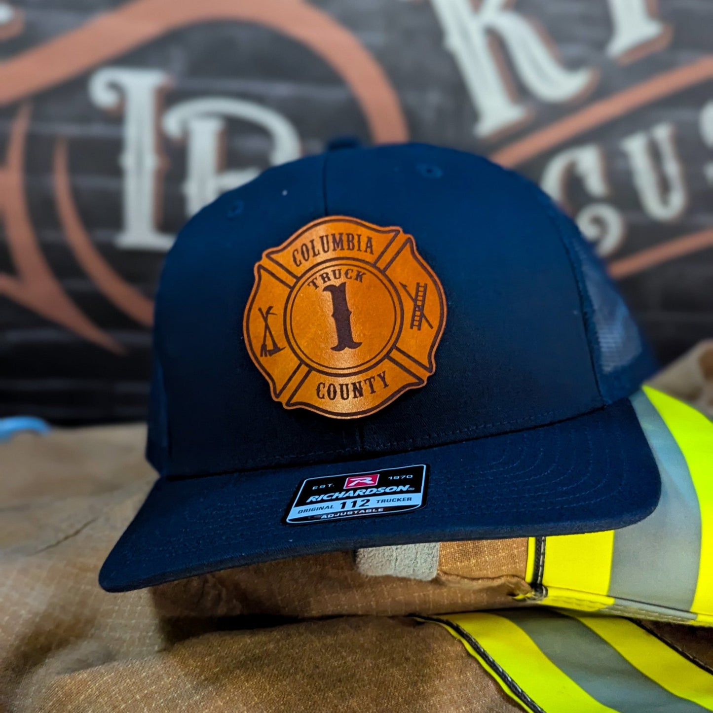 Navy Richardson firefighter hat with custom Maltese leather patch design, classic and durable fire department headwear.