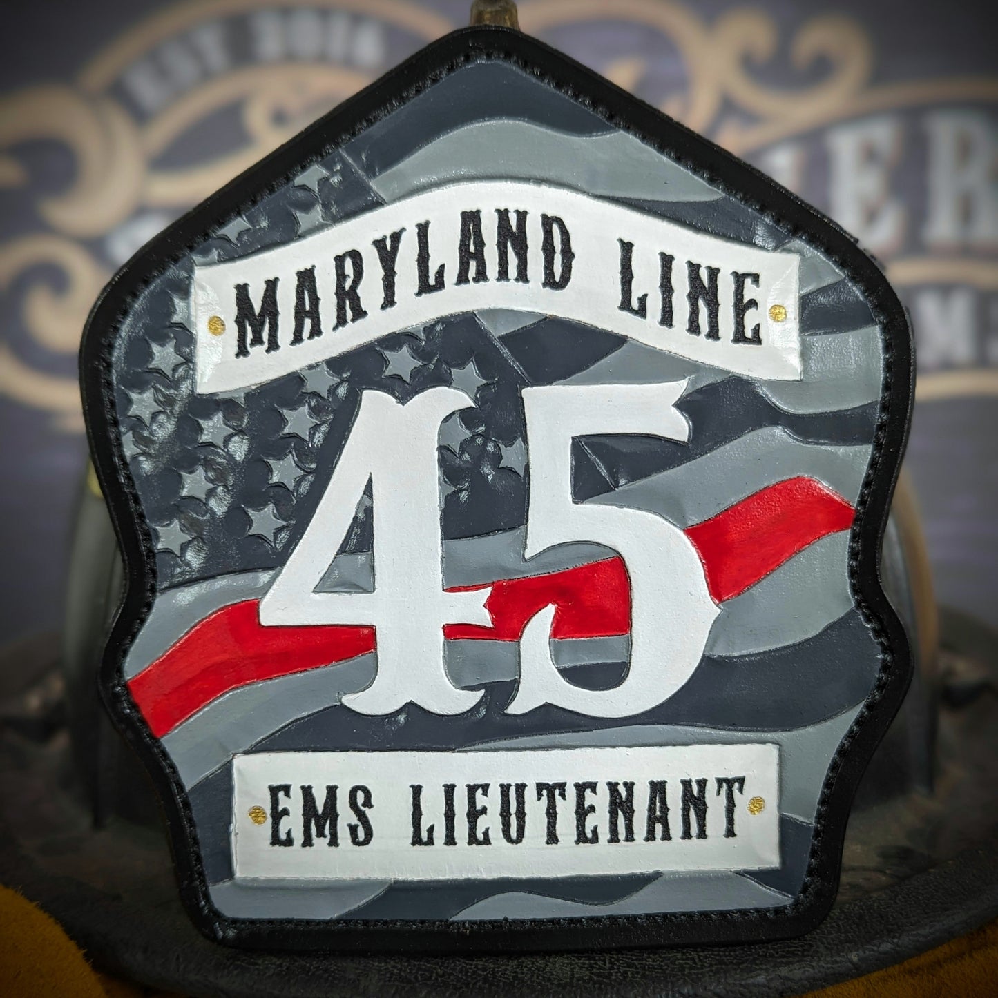 Custom firefighter helmet shield with American flag design, personalized leather front with unit number and firefighter name. Handcrafted fire helmet shield for professional firefighters, made for durability and pride on the job.