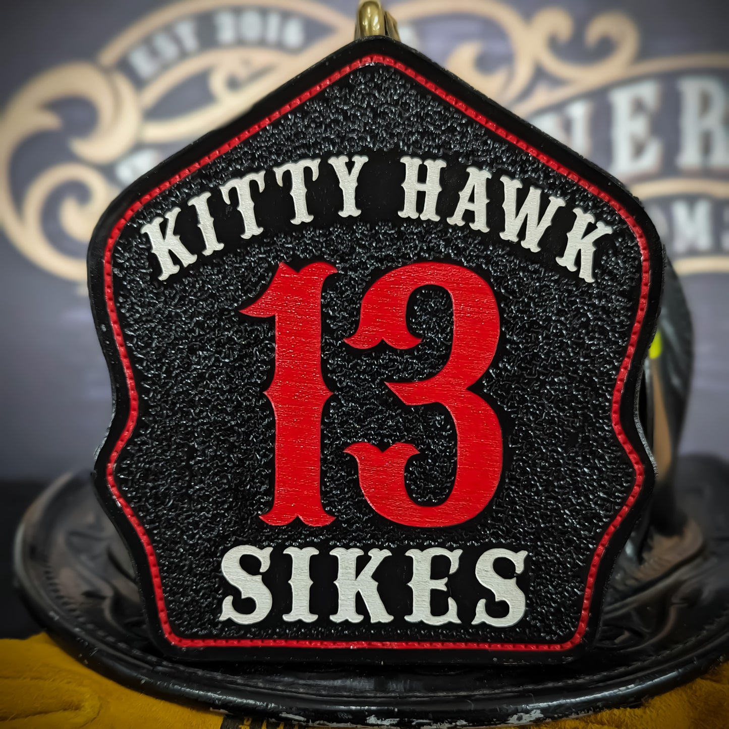 Black leather firefighter helmet shield with Kitty Hawk lettering, bold red number 13, and Sikes name.