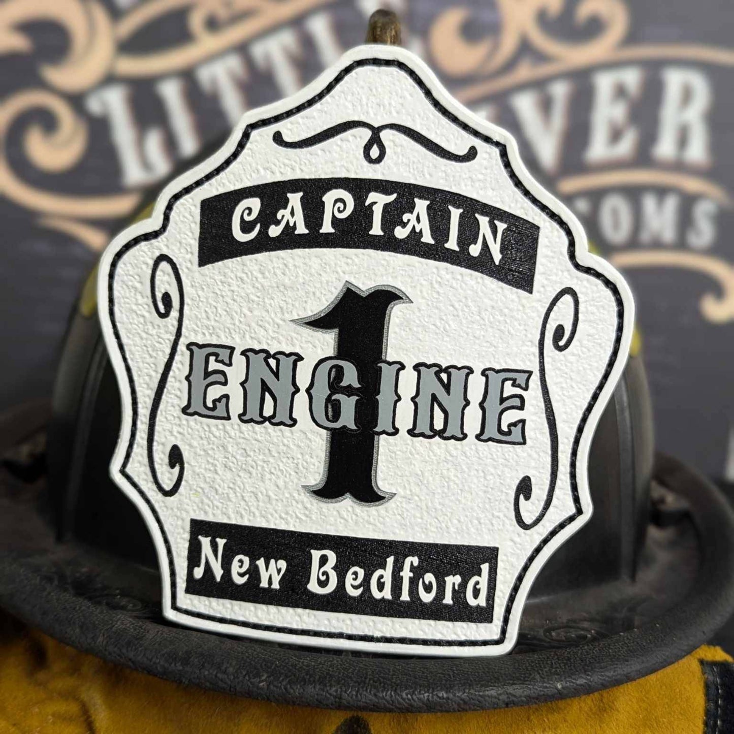 White captain engine leather firefighter helmet shield with framed black outline.