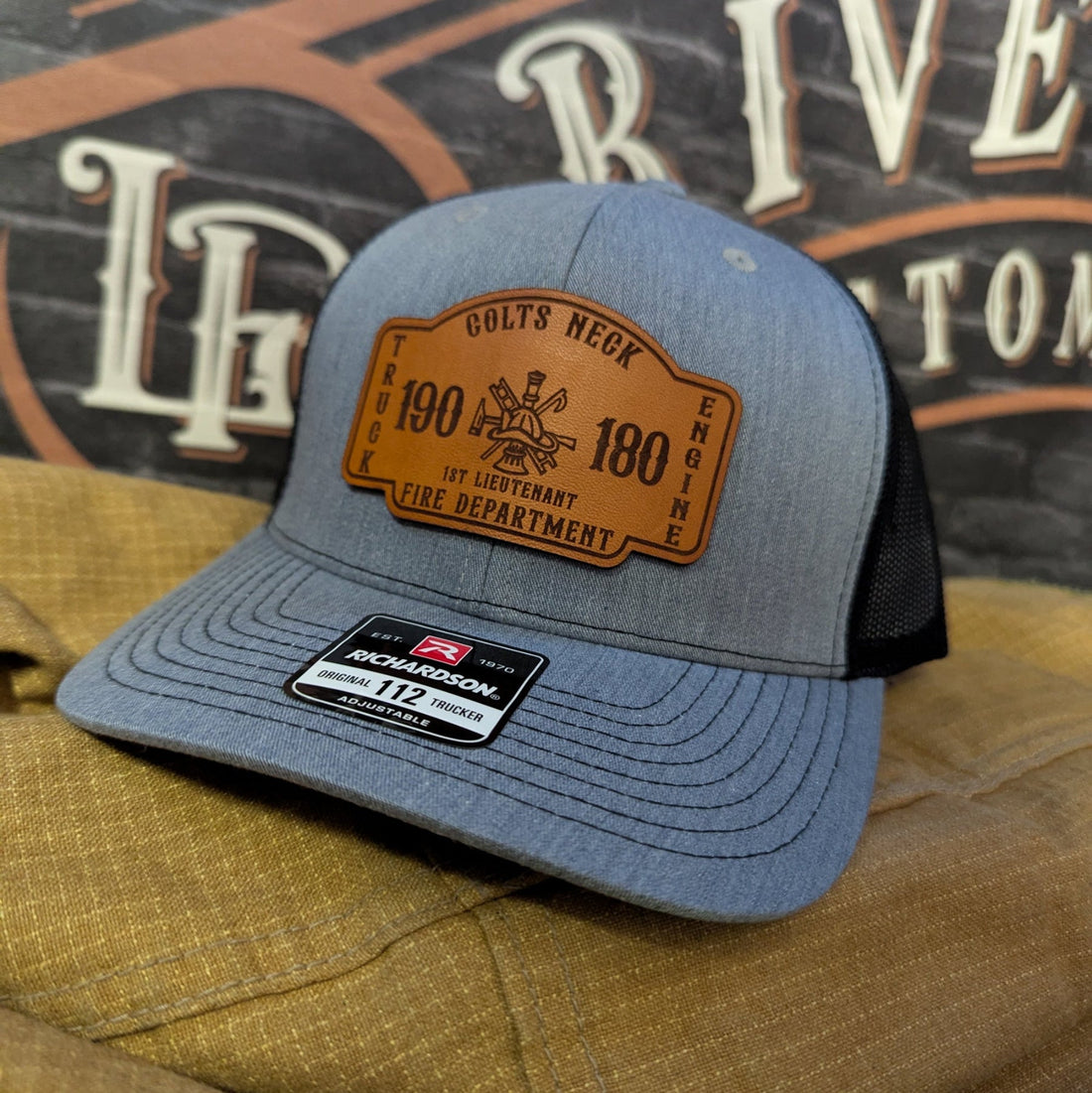 Custom firefighter hats with leather patches arranged for design comparison