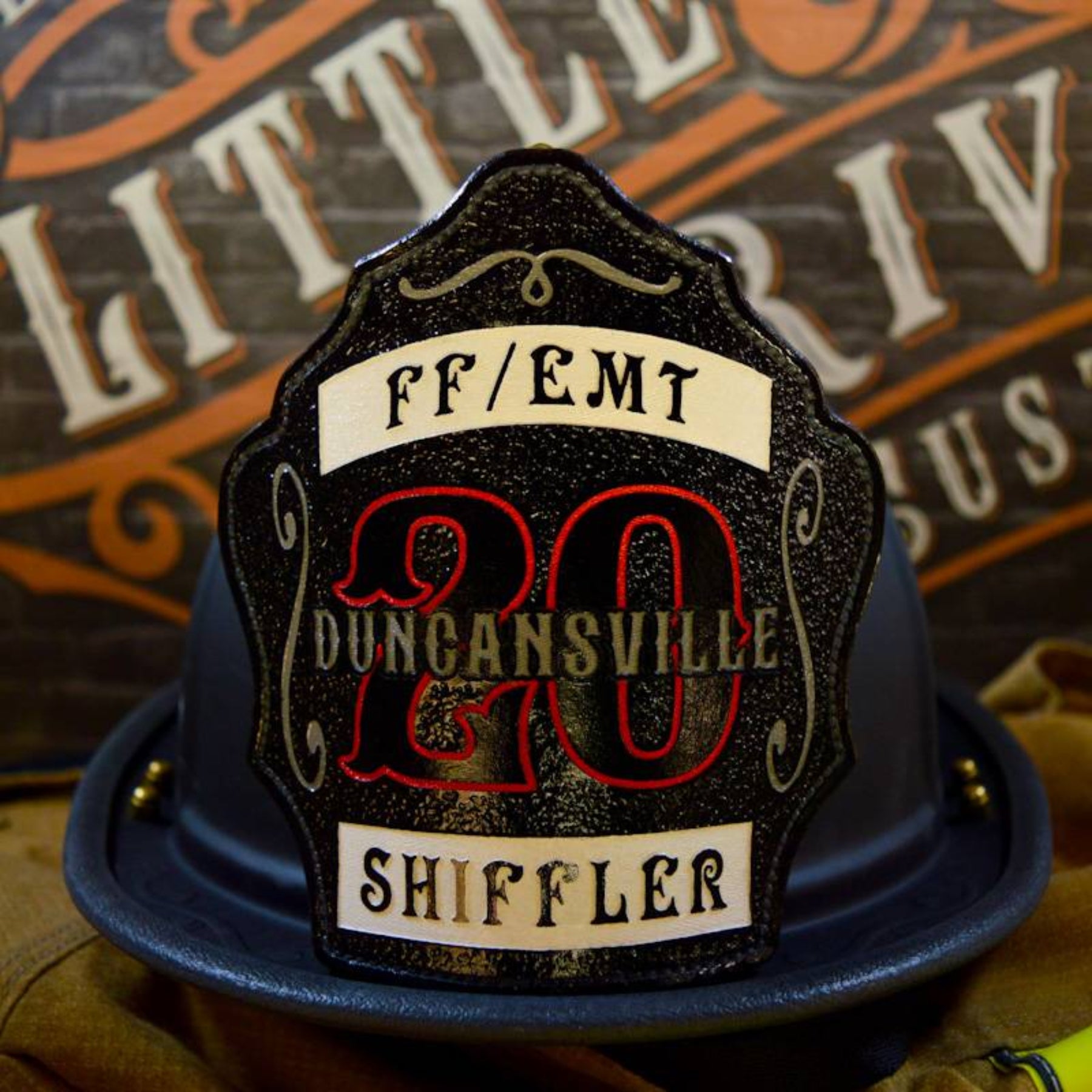 Custom leather firefighter helmet shield with bold yellow accents on a textured black background, shown on a helmet.