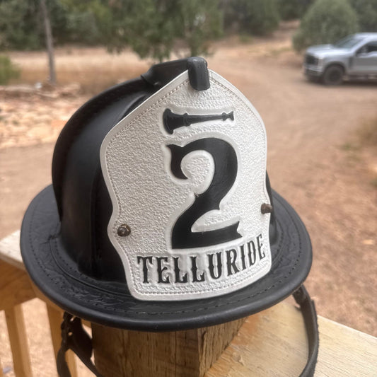 Custom firefighter helmet shield for Telluride Co. 2 – black and white leather with bold lettering, handcrafted by Little River Customs.