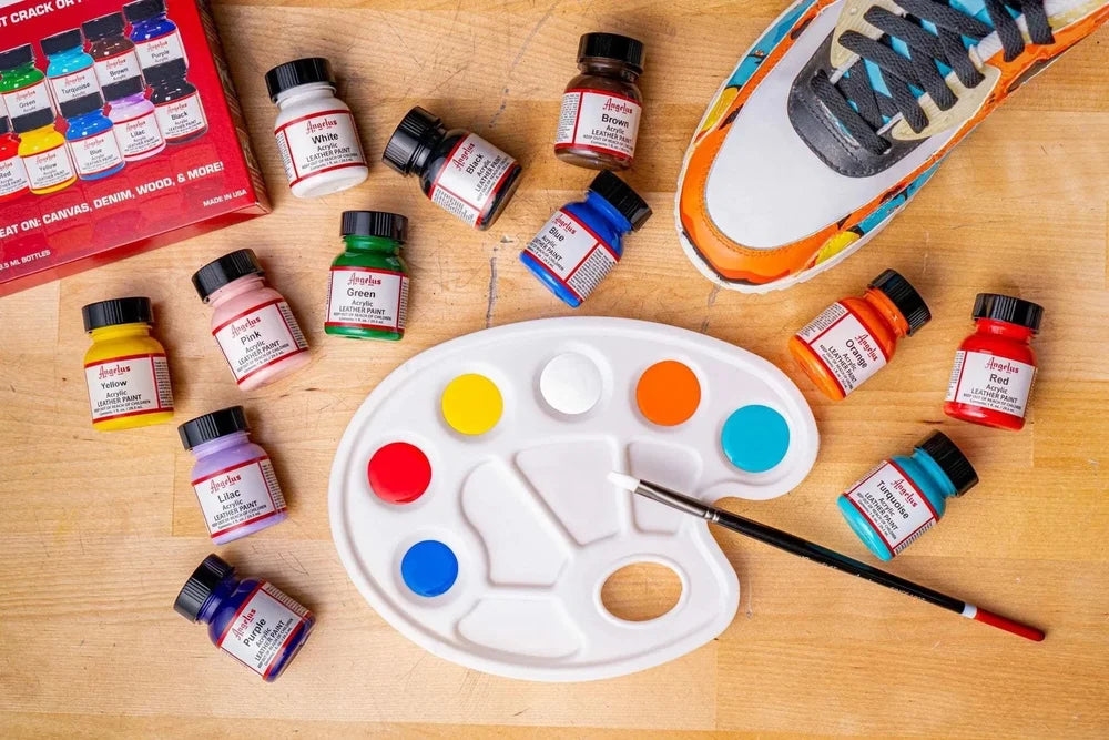 Angelus Best Sellers paints arranged with a mixing palette, brush, and sneaker