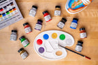 Angelus metallic and pearlescent paints beside a mixing palette and custom sneaker