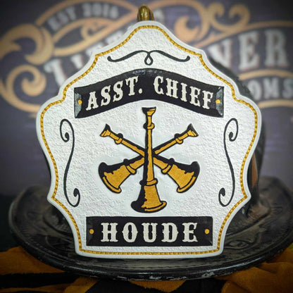 Assistant chief helmet shield in warm tan with gold crossed bugles and red accents.