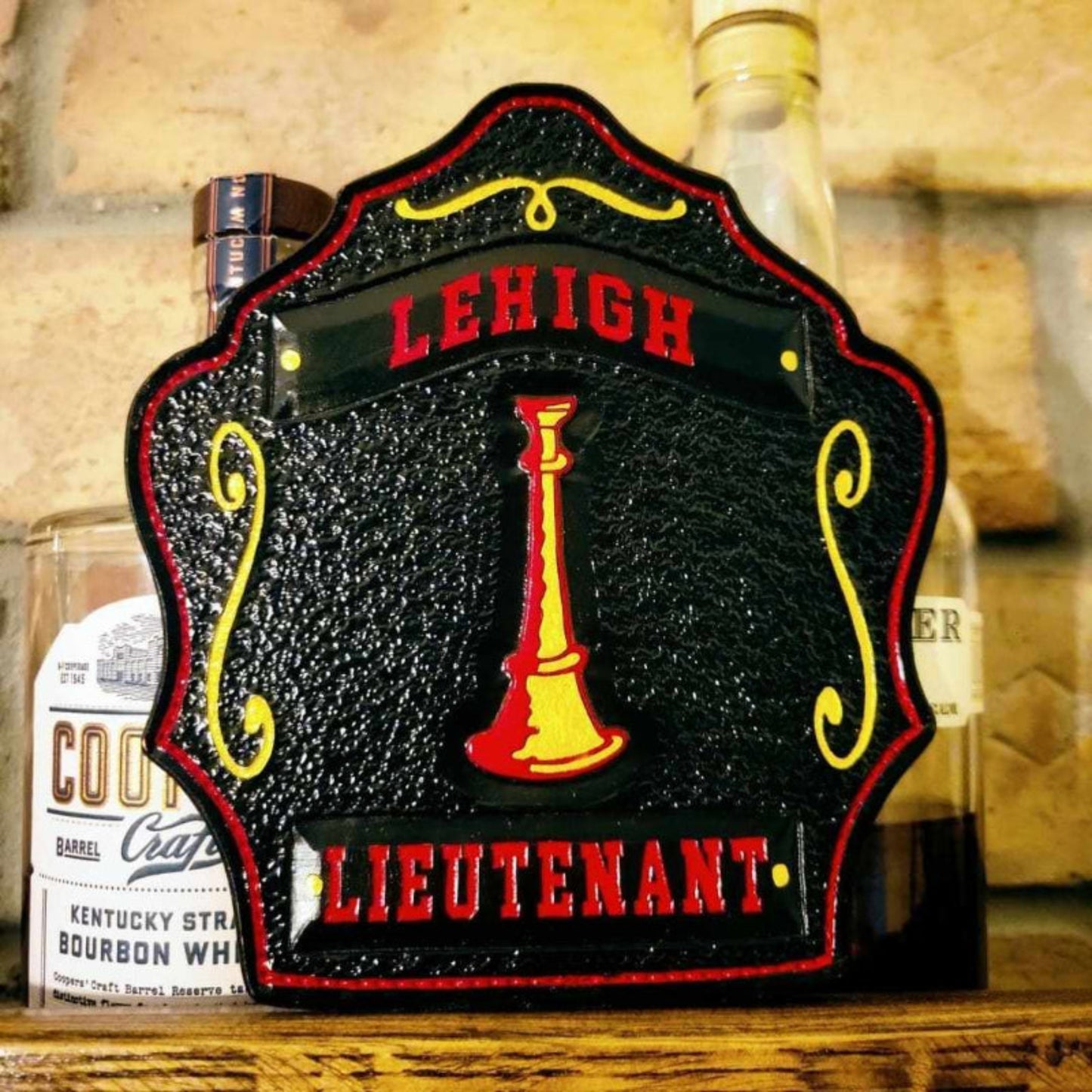 Black center firefighter helmet shield with red banners and gold trim—lieutenant layout.