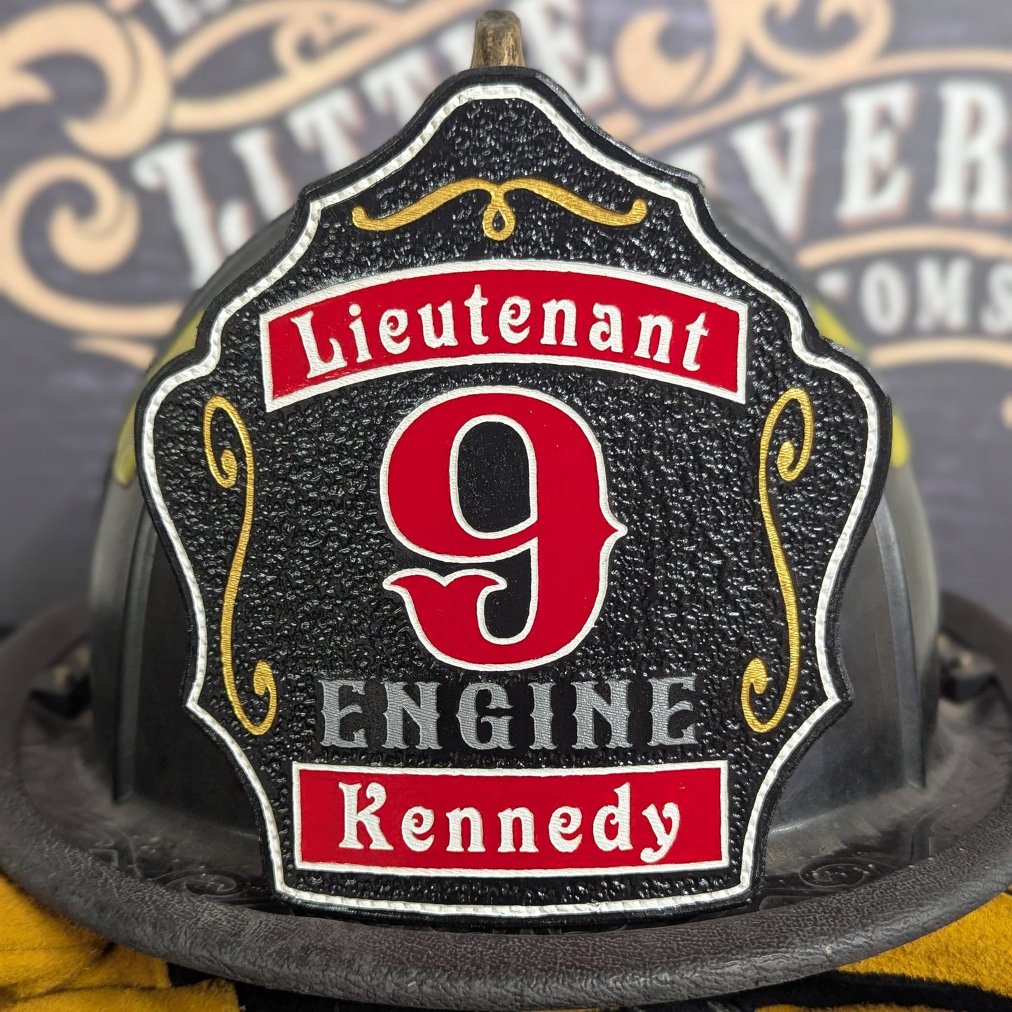 Black leather firefighter helmet shield with red numeral and lieutenant layout.