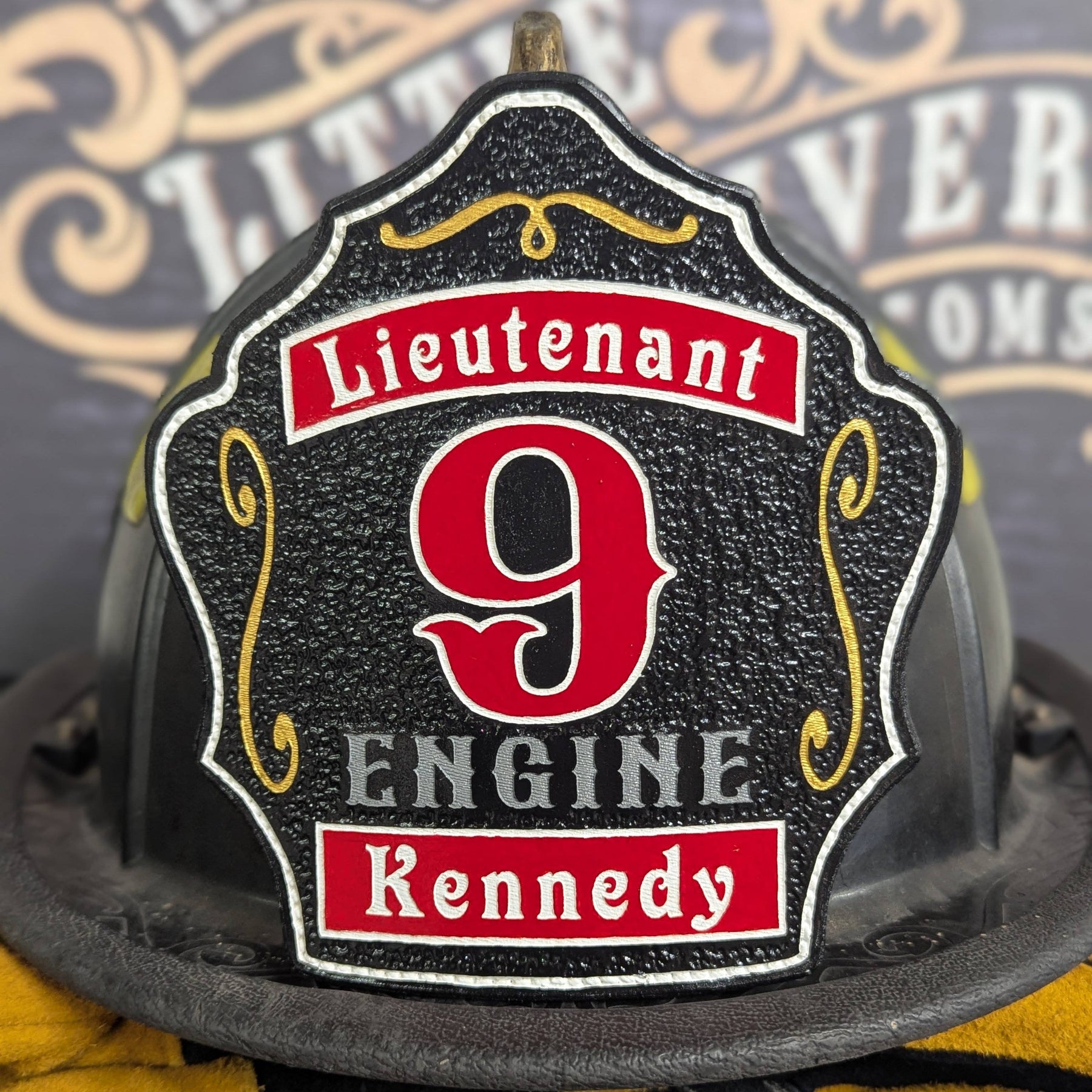 Black leather firefighter helmet shield with red numeral and lieutenant layout.
