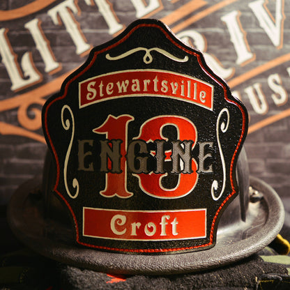 Black leather firefighter helmet shield with copper numerals and thin framed border.