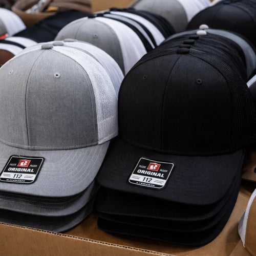 blank richardson hats stacked in bulk ready for customization