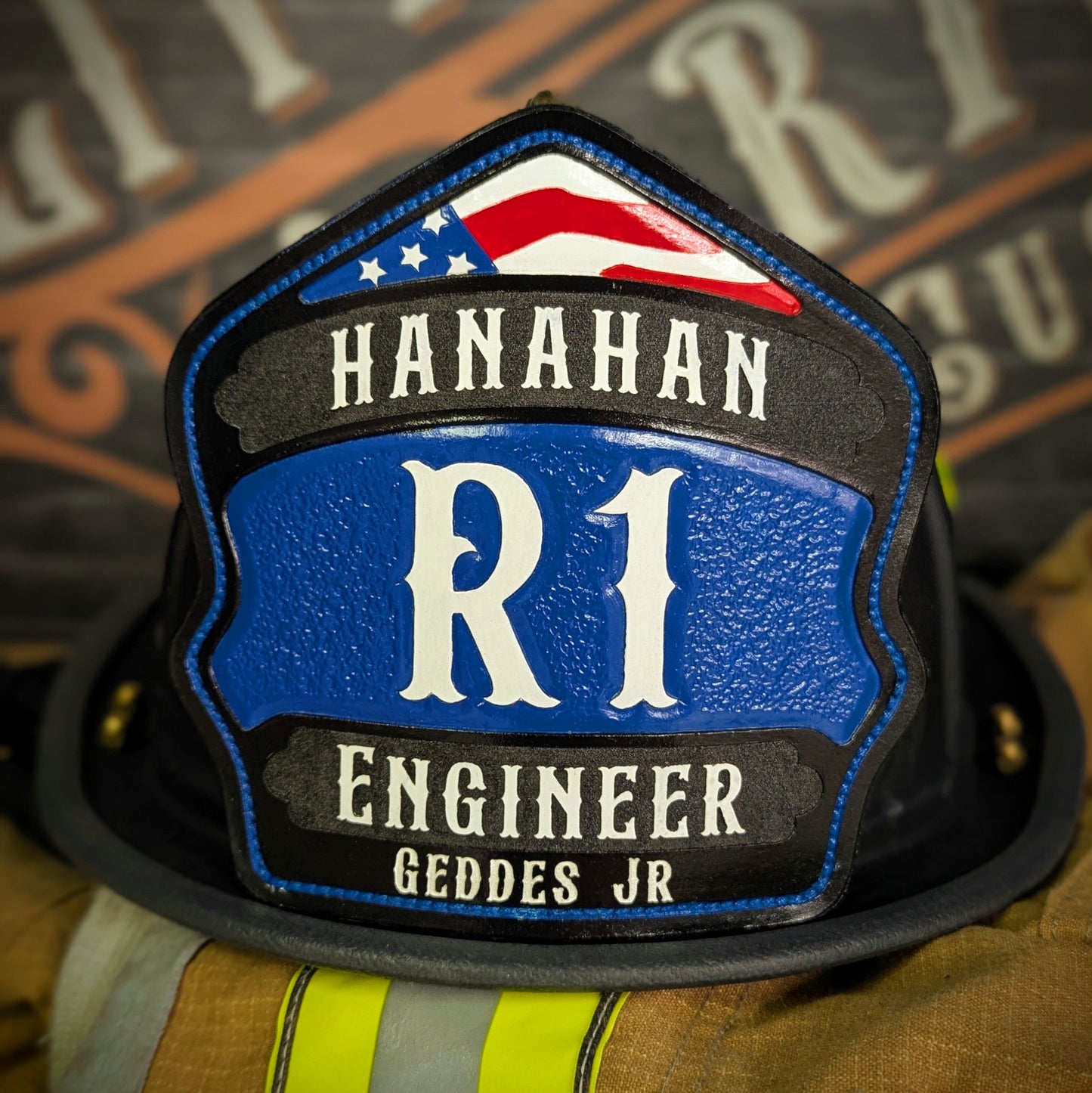Blue-panel leather firefighter helmet shield with white block insignia and red arch, engineer style.