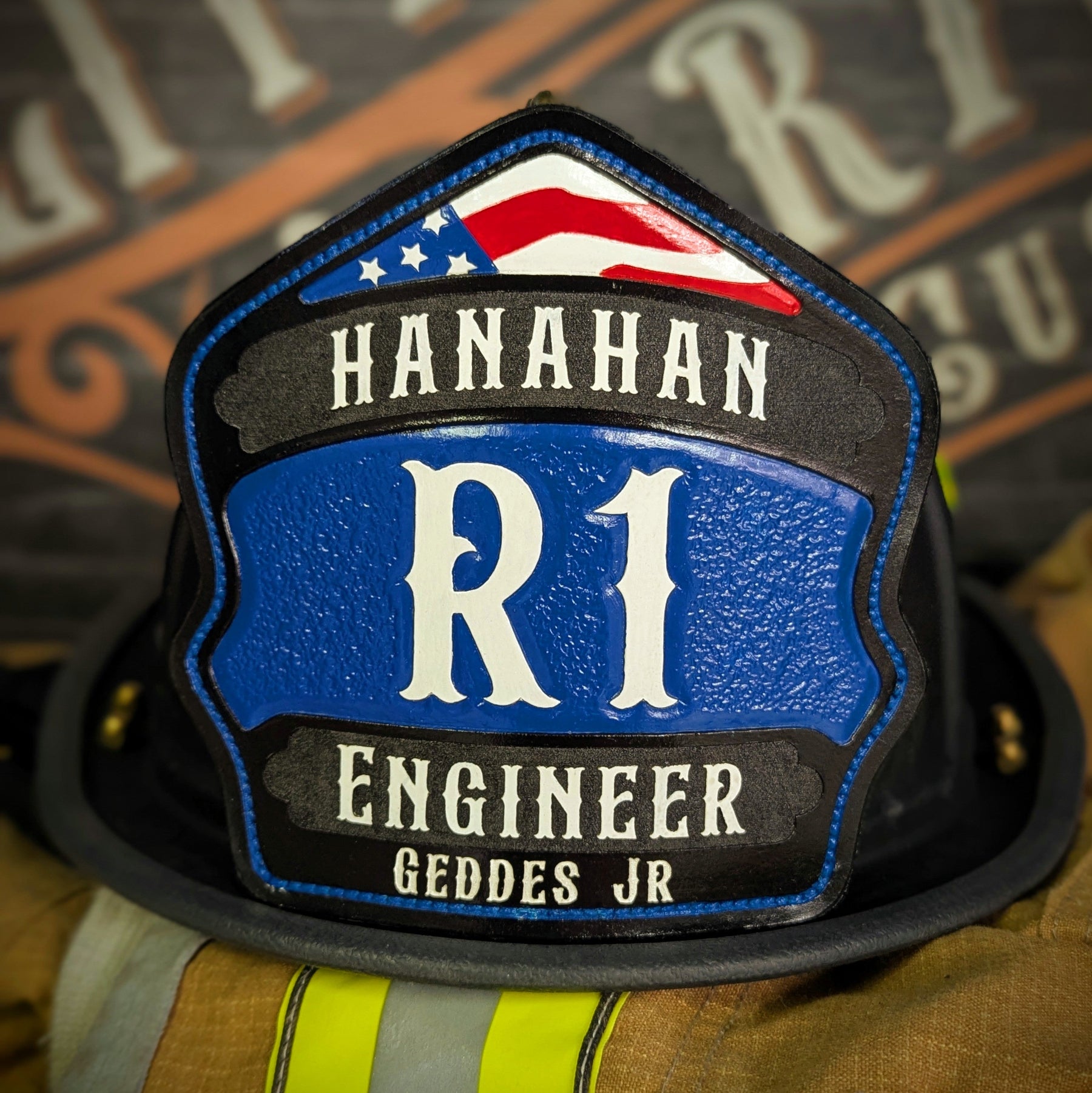 Blue-panel leather firefighter helmet shield with white block insignia and red arch, engineer style.