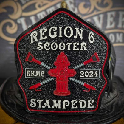 Custom leather firefighter helmet shield with red hydrant emblem and crossed axes on a textured black field with red border—hand-painted and helmet mounted.
