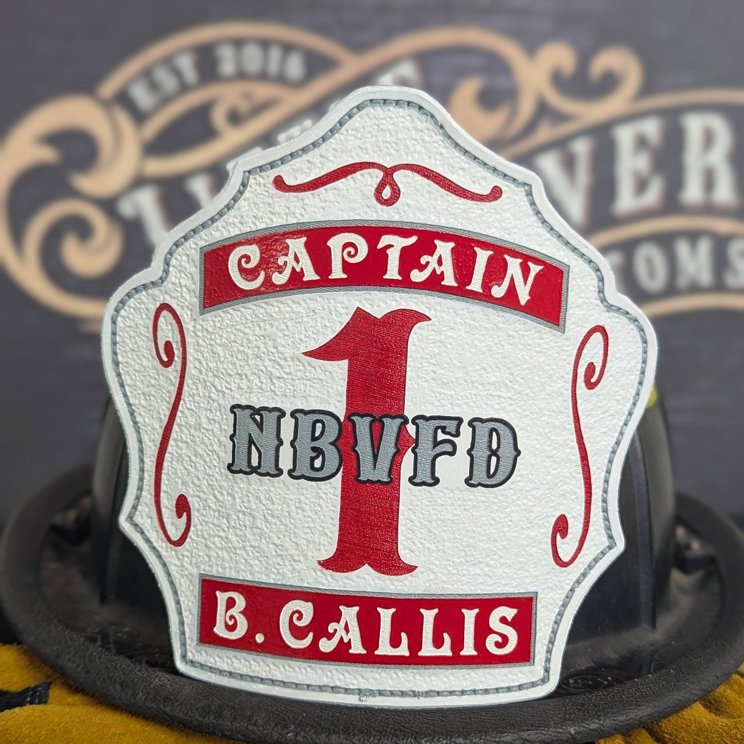 White leather firefighter helmet shield with bold red number 1 and captain lettering, custom fire department gear.
