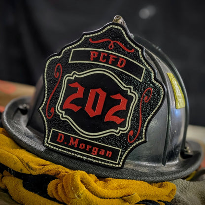 Custom black leather firefighter helmet shield with number 202 in red, red banners, and scroll accents