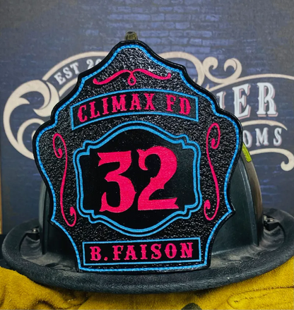 Custom firefighter helmet shield with number 32, Climax FD lettering, and B. Faison name in black leather with bold pink and blue details.